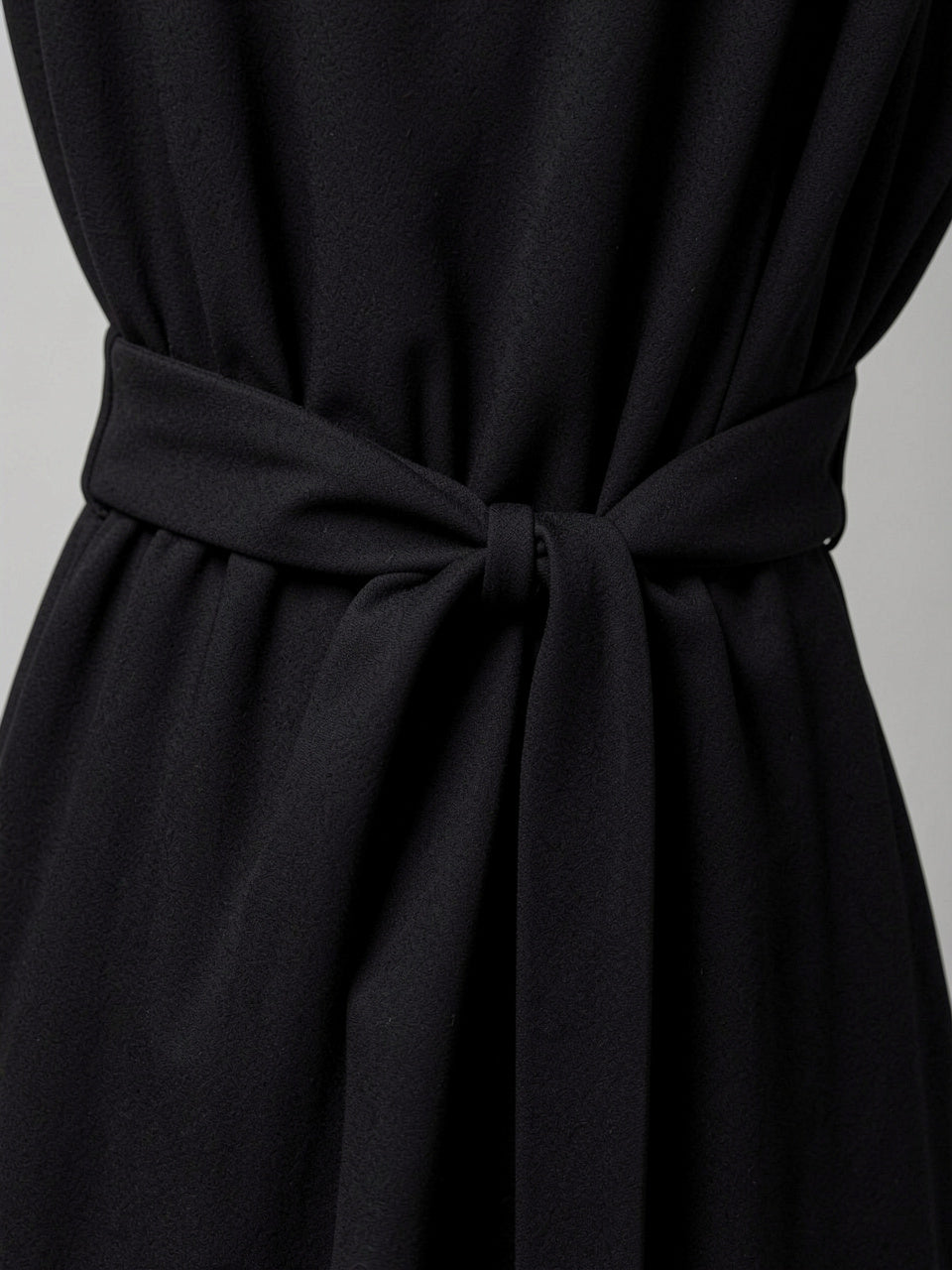Fabric detail of tied waist sash on wide-leg jumpsuit