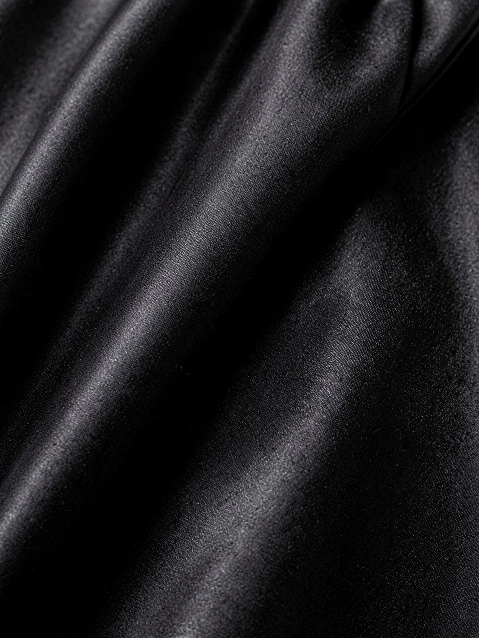 Close-up detail of black glossy satin fabric