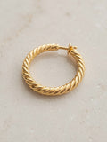 Close-up detail of textured braided gold hoop earring