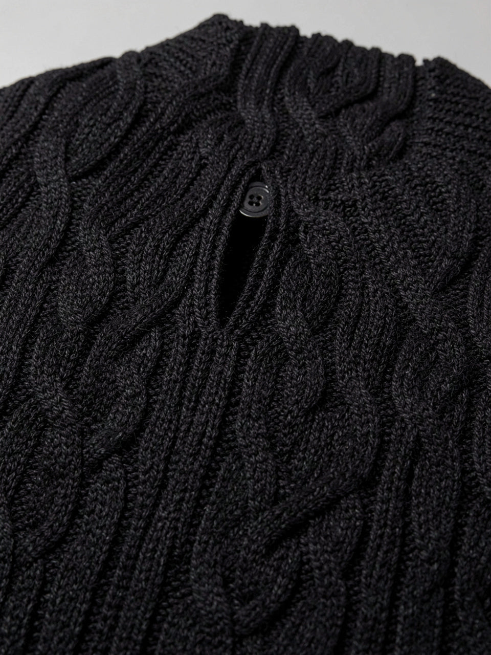 Fabric detail of cable-knit texture and keyhole button closure