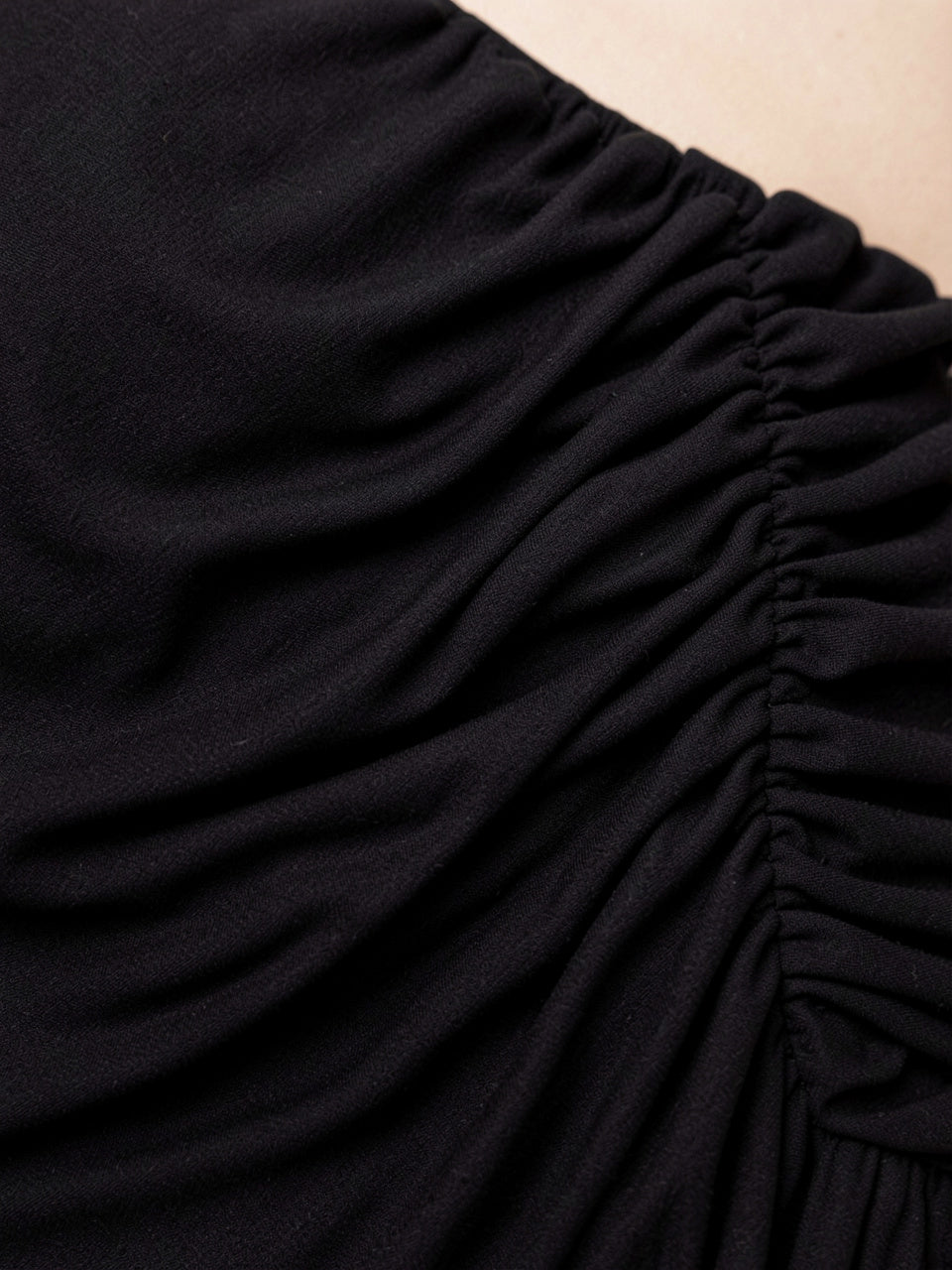 Close-up detail of black ruched fabric draping