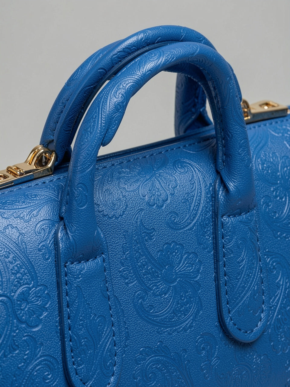 Detalle de textura de cuero grabado floral paisley y asa del Top-Handle Handbag